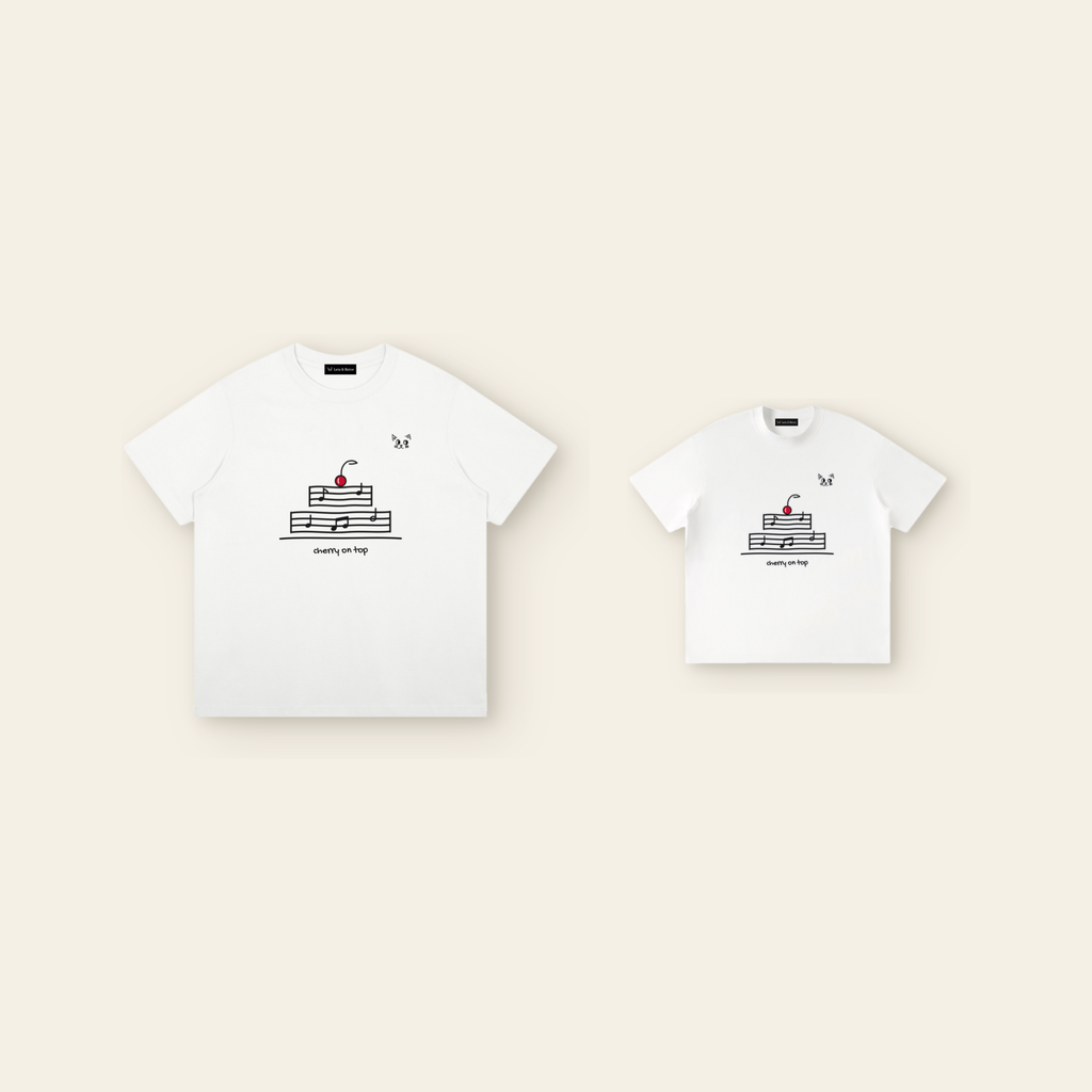 One kids' t-shirt and one adult t-shirt laid side by side