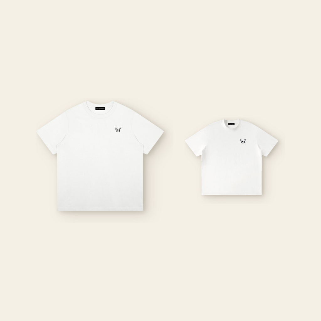 One kids' t-shirt and one adult t-shirt laid side by side