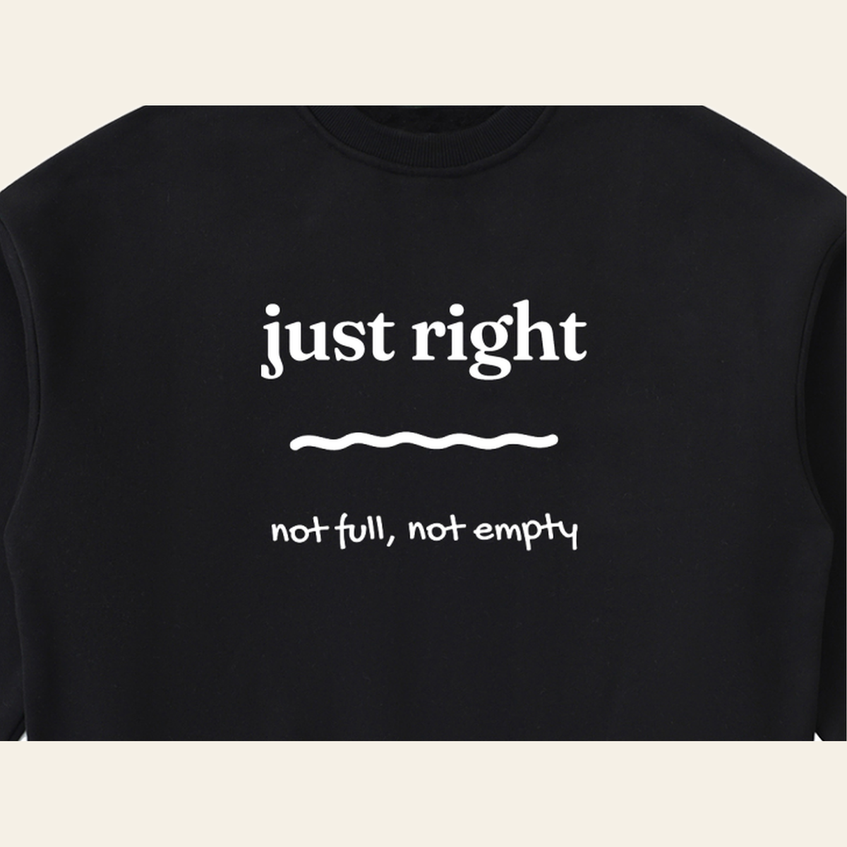 Close-up of the Just Right mark printed on the Black sweatshirt