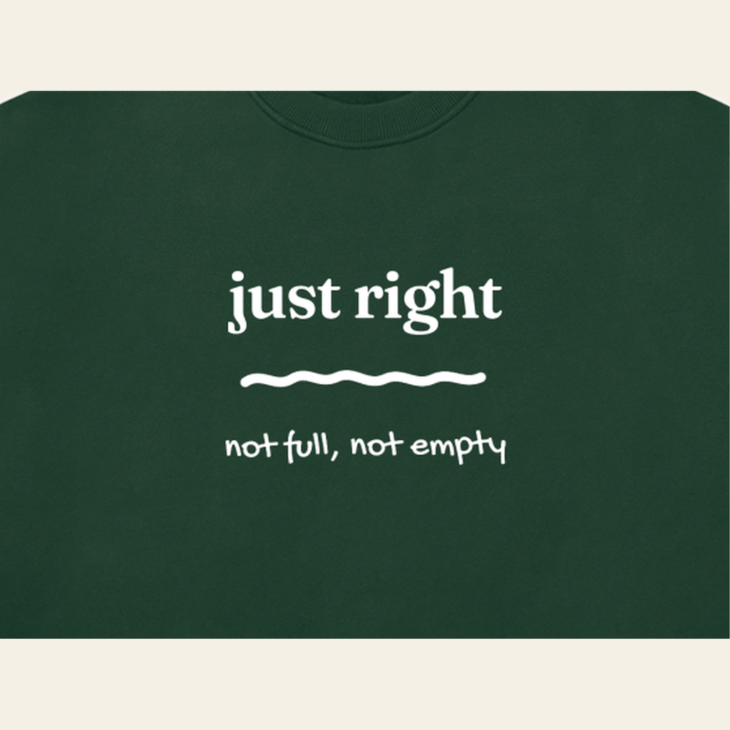 Close-up of the Just Right mark printed on the Dark Green sweatshirt