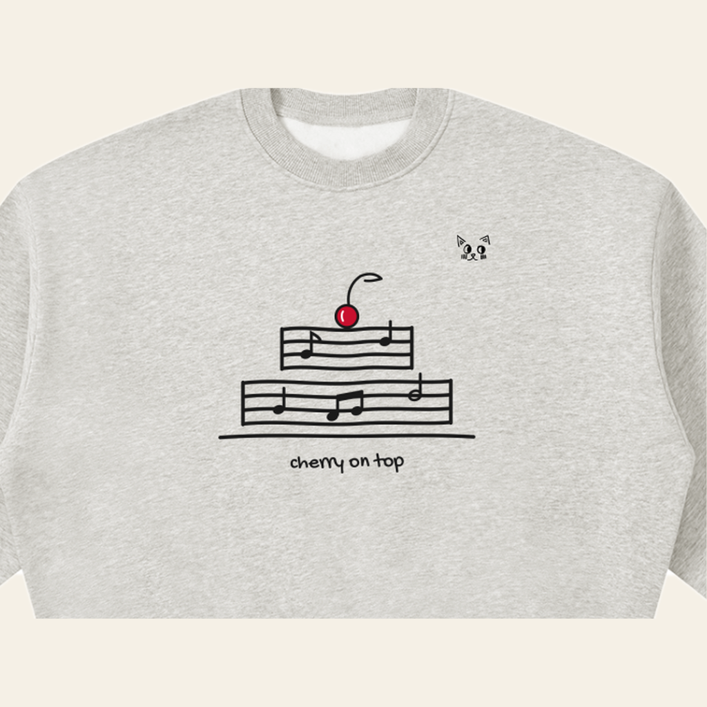 Close-up of the Cherry on Top mark printed on the Heather Gray sweatshirt