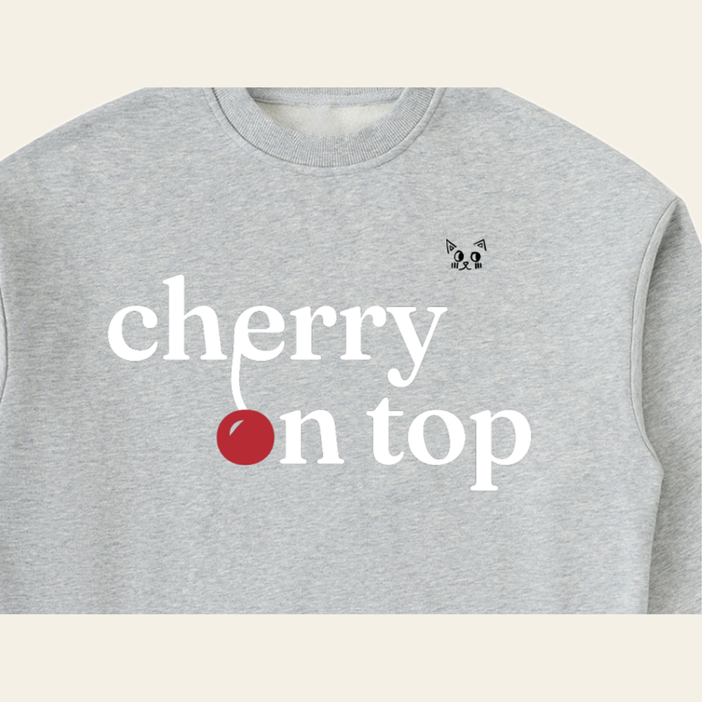 Close-up of the Cherry on Top mark printed on the Heather Gray sweatshirt