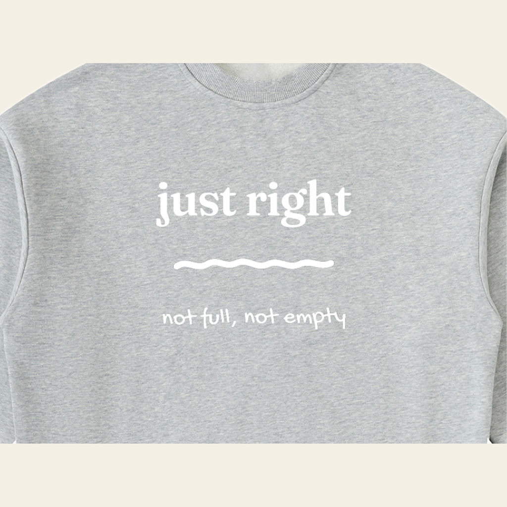 Close-up of the Just Right mark printed on the Heather Gray sweatshirt