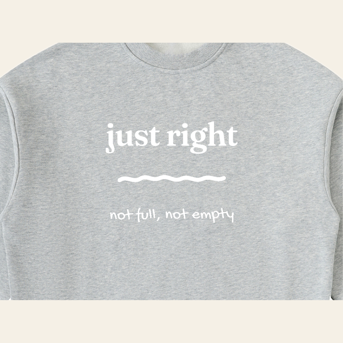 Close-up of the Just Right mark printed on the Heather Gray sweatshirt