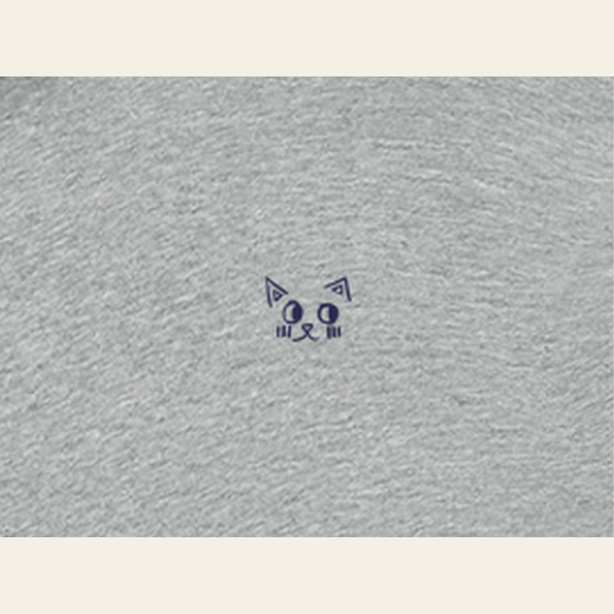 Close-up of the Batce mark printed on the Heather Gray zip hoodie