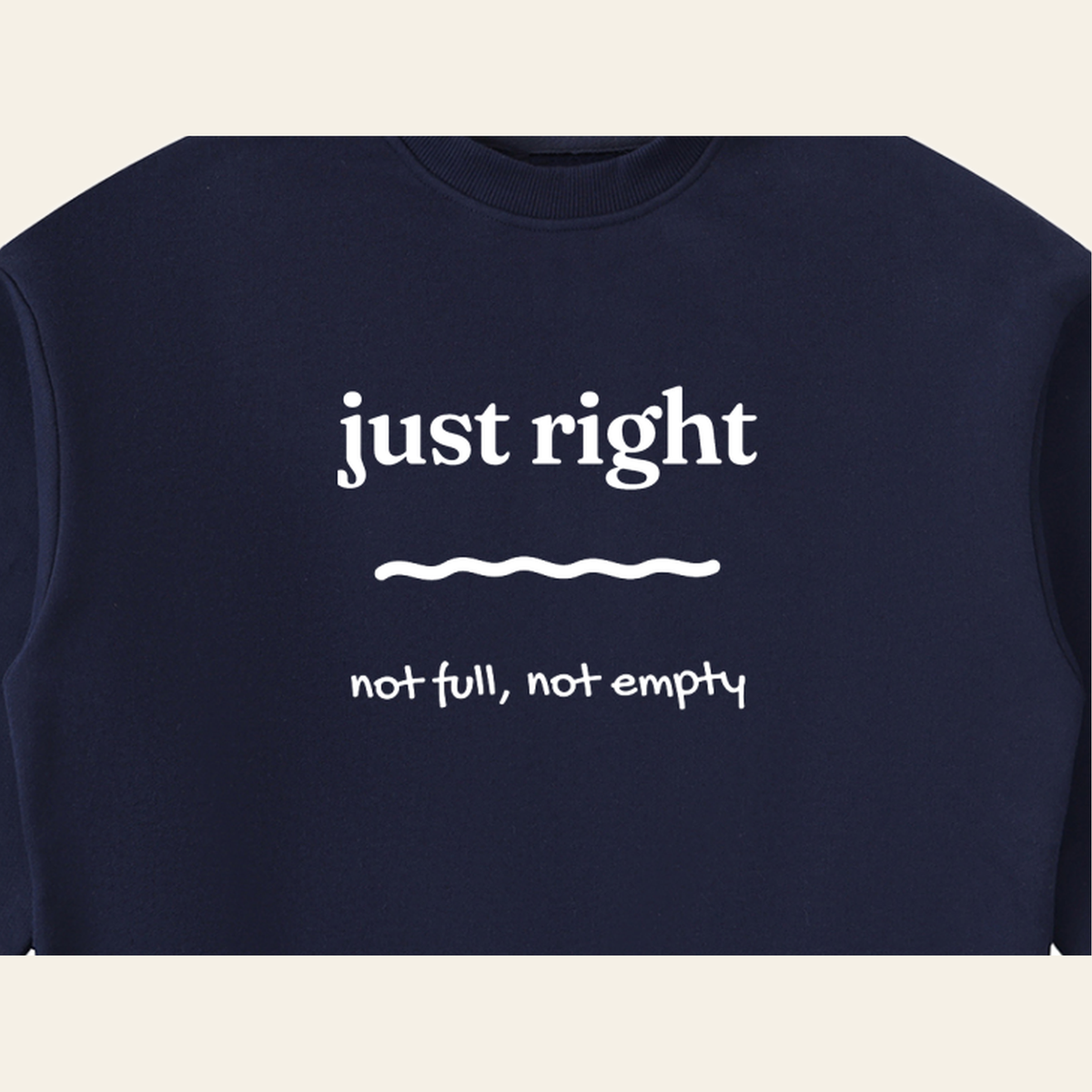 Close-up of the Just Right mark printed on the Navy Blue sweatshirt