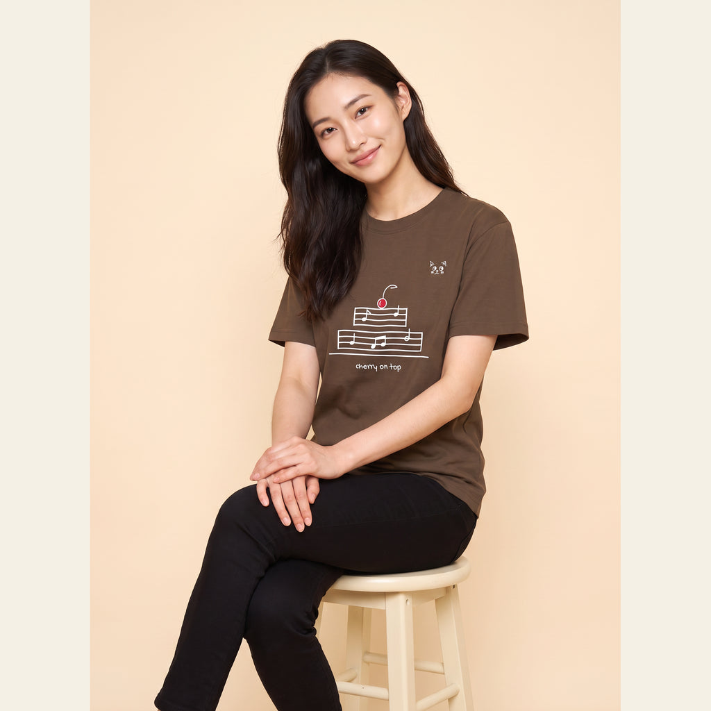 The Cherry on Top T-Shirt – Adult in Brown, worn by an adult, with the small Cherry on Top mark on the chest