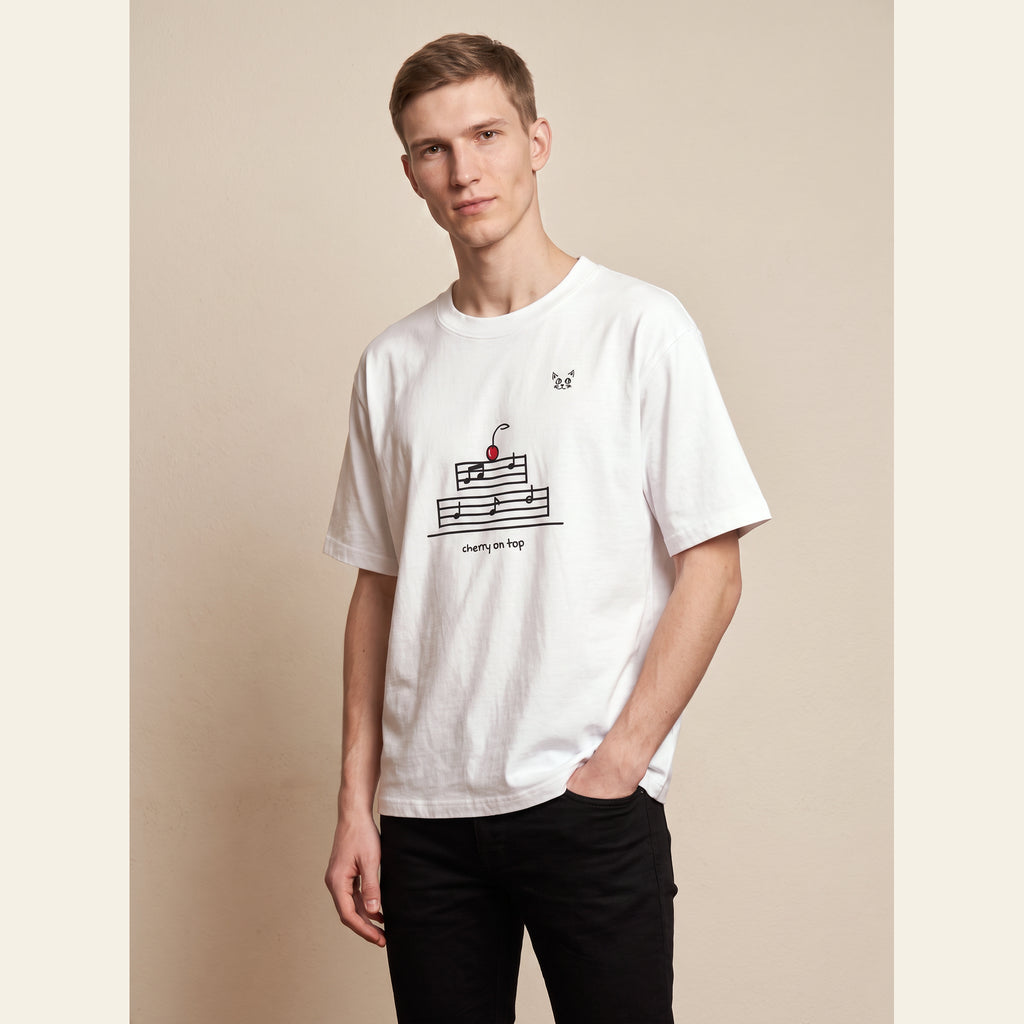 The Cherry on Top T-Shirt – Adult in White, worn by an adult, with the small Cherry on Top mark on the chest