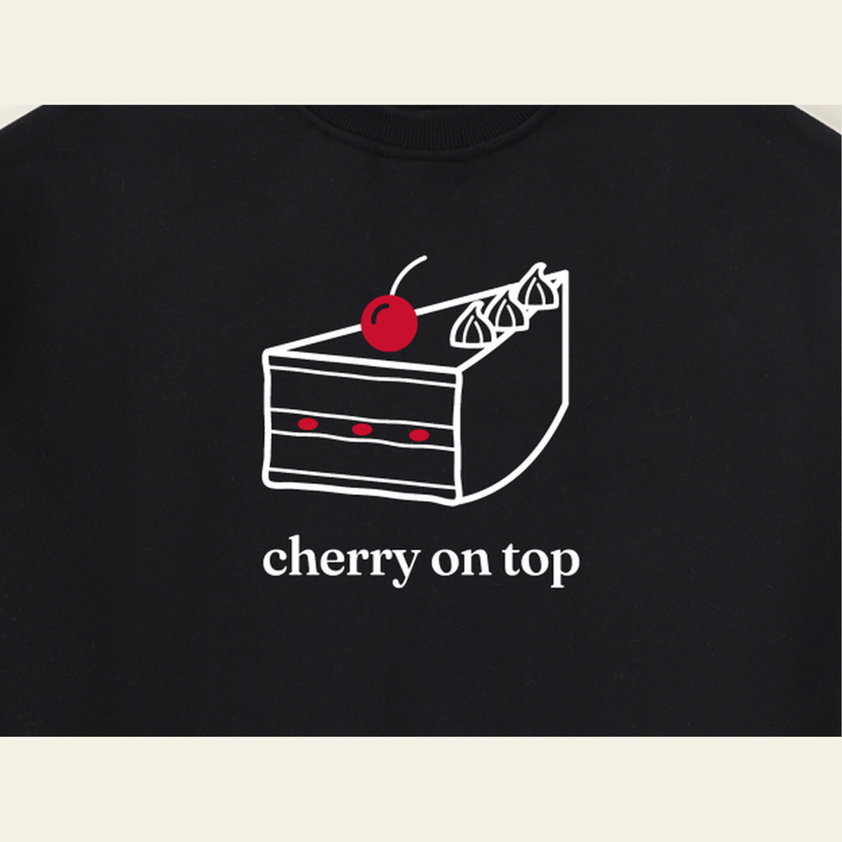 Close-up of the Cherry on Top mark printed on the Black sweatshirt