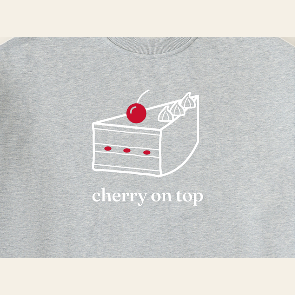 Close-up of the Cherry on Top mark printed on the Heather Gray sweatshirt