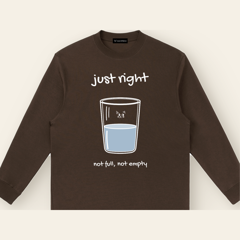 Close-up of the Just Right mark printed on the Brown long-sleeve t-shirt